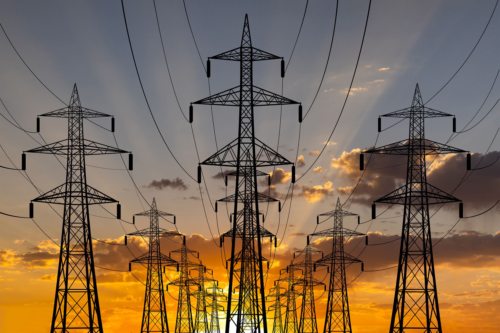 Steel-towers,-high-voltage-wires,-stretching-to-the-sunset
